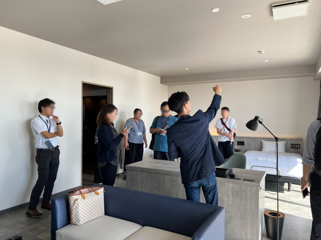 DX視察ツアーで、様々なシステムが実装された宿泊部屋を見学する参加者