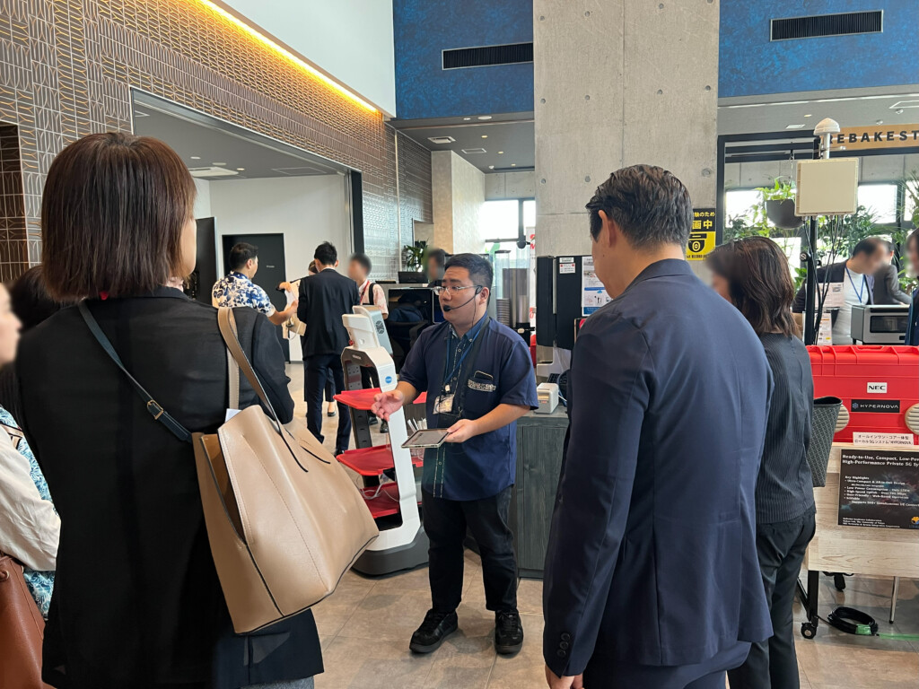 ドンリンカーロボットが自動で飲み物を入れる様子を見学するDX視察ツアーの参加者