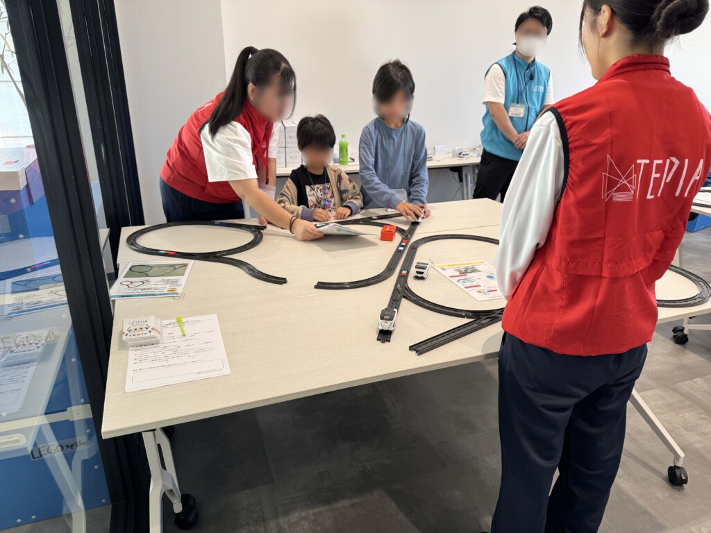 プログラミングで動く電車で遊ぶ子供たち