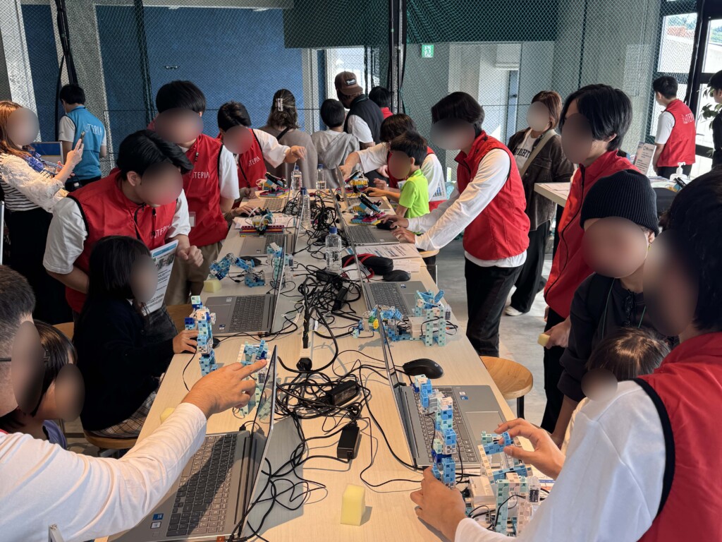 たくさんの子供たちがプログラミングでロボットを動かしている様子
